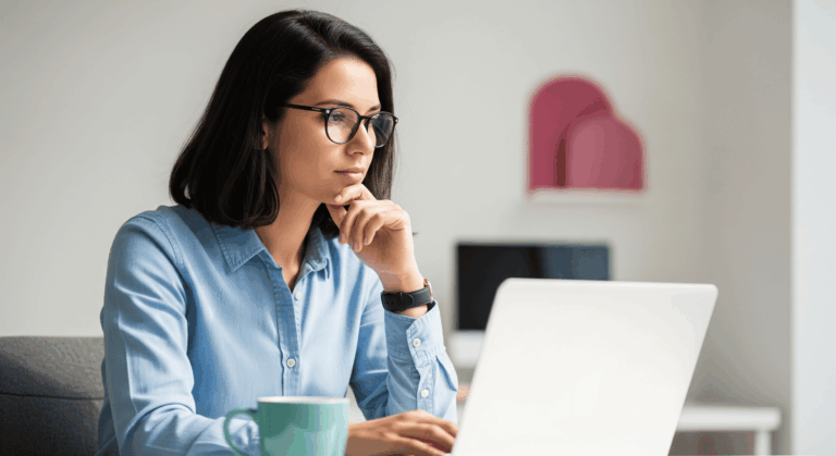 Woman concentrating while working on a laptop.