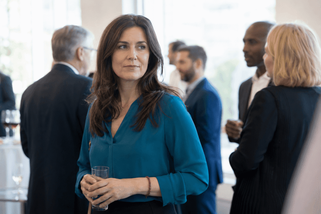 Professional woman appearing uncomfortable and mentally drained at a networking event