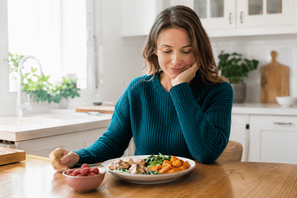 Woman thoughtfully eating a healthy meal at home to support stress management and healthy habits